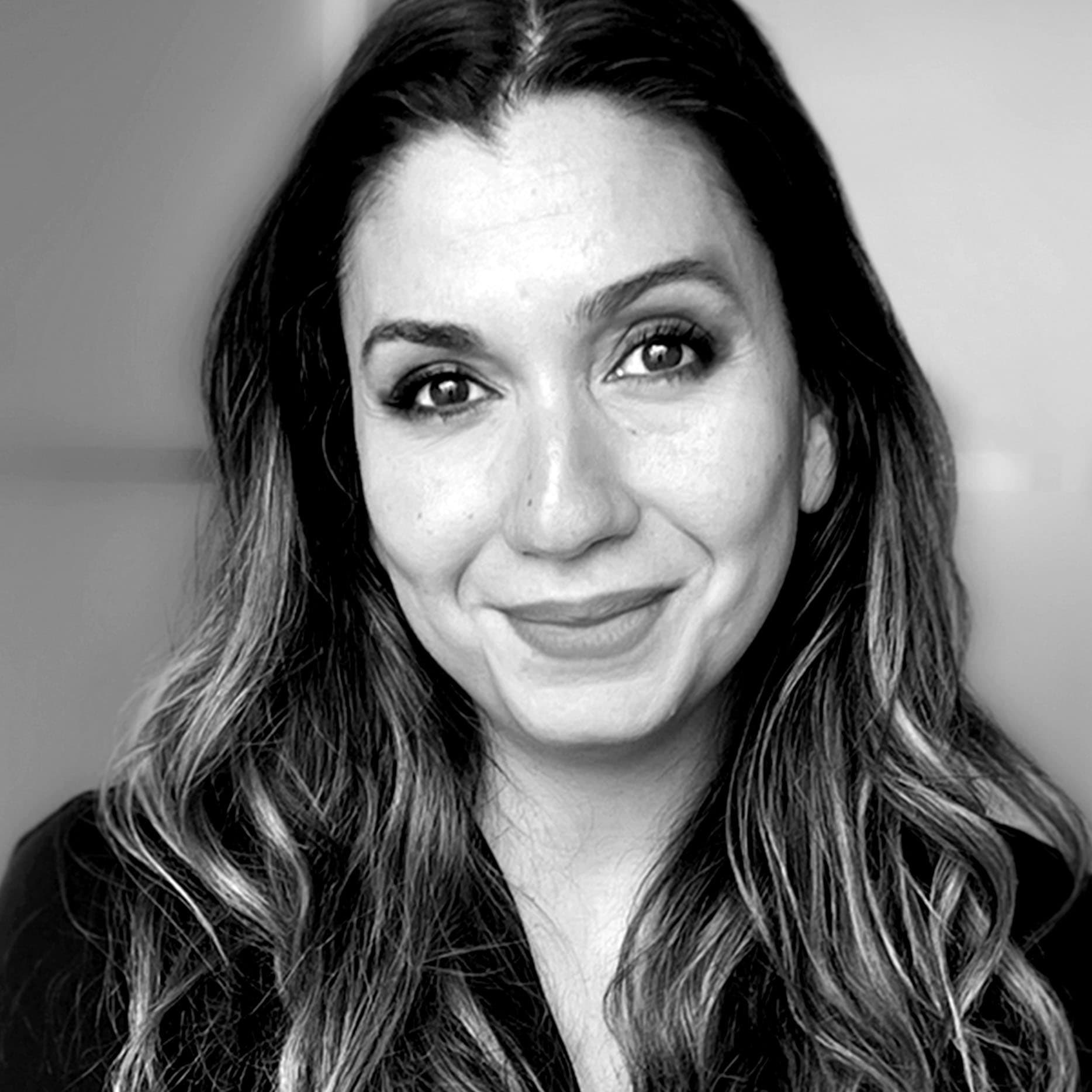 A black and white close-up portrait of Marina Bournas smiling warmly.