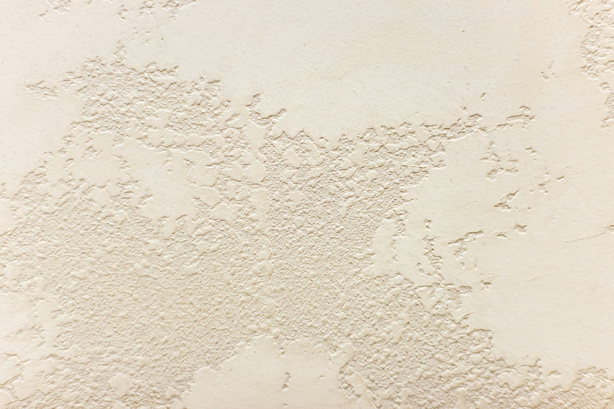 A beige wall featuring a subtle textured surface. 