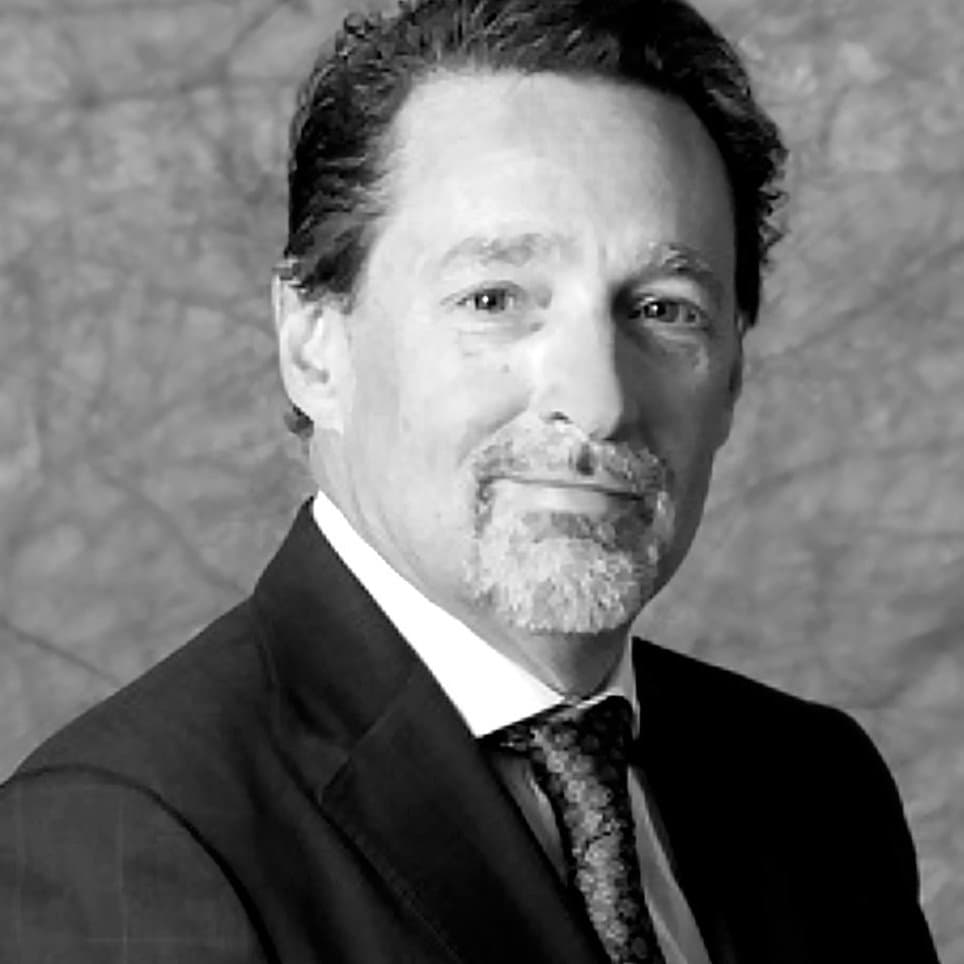 A black and white close-up portrait of Robert Morton smiling warmly.