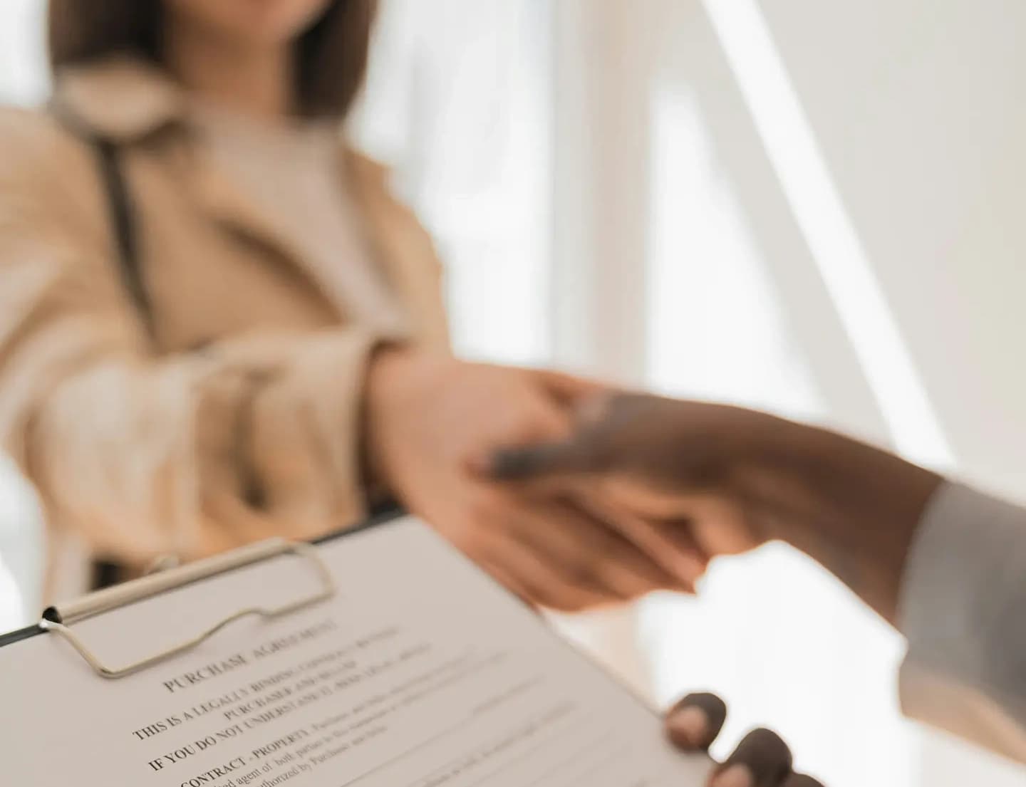 A close-up of a professional handshake between two people. 