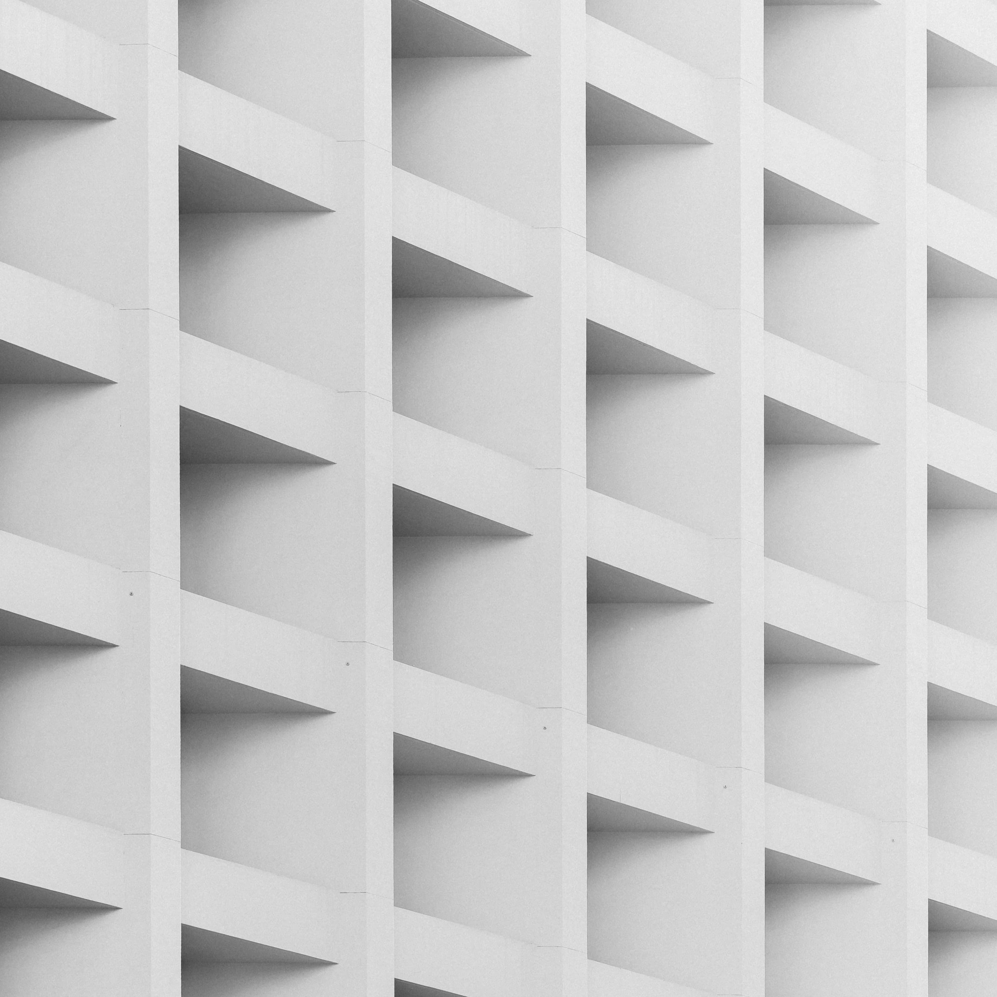 A white wall covered in an array of evenly spaced, box-shaped holes.